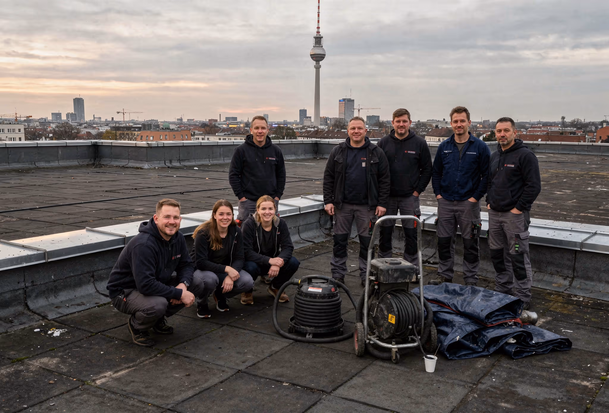Teamfoto auf einem Berliner Dach — nach abgeschlossener Dachrinnenreinigung